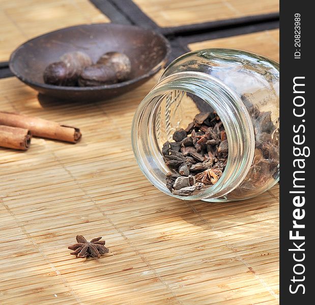 Various spices placed in recipients and on a straw mat. Various spices placed in recipients and on a straw mat