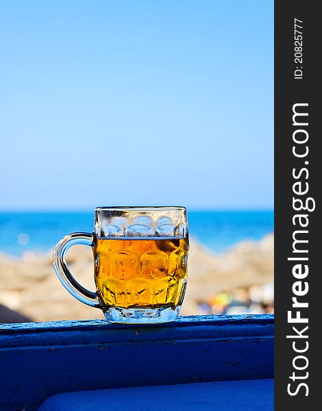 Mug of beer against blue sky, sea and beach. Mug of beer against blue sky, sea and beach.