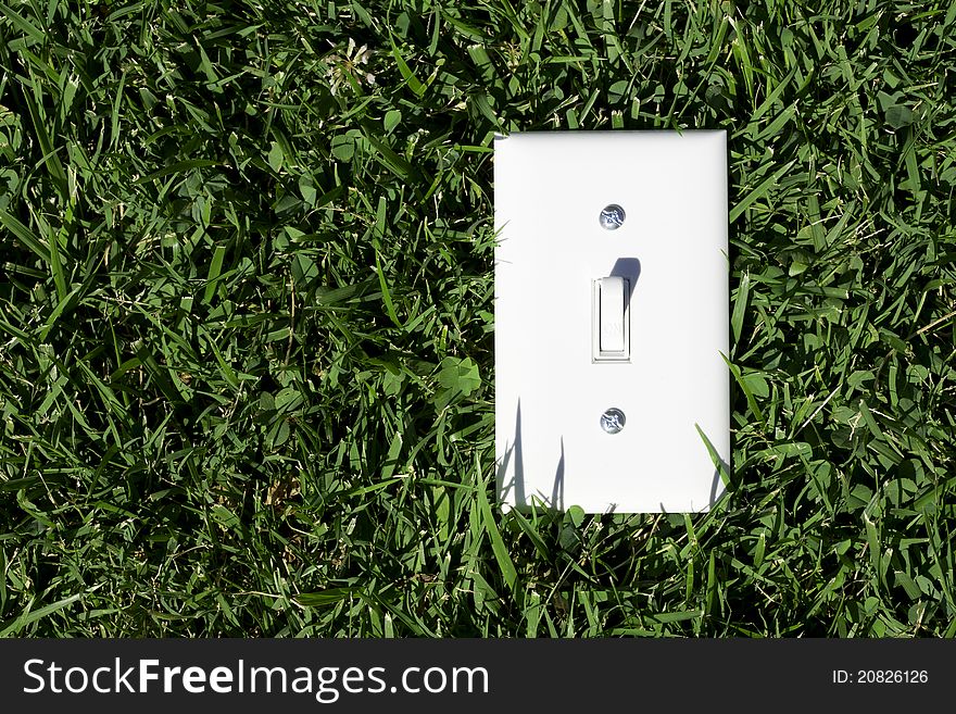An electrical switch in on position located on the grass