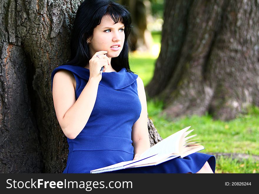 Beautiful student girl studying in green park. Beautiful student girl studying in green park