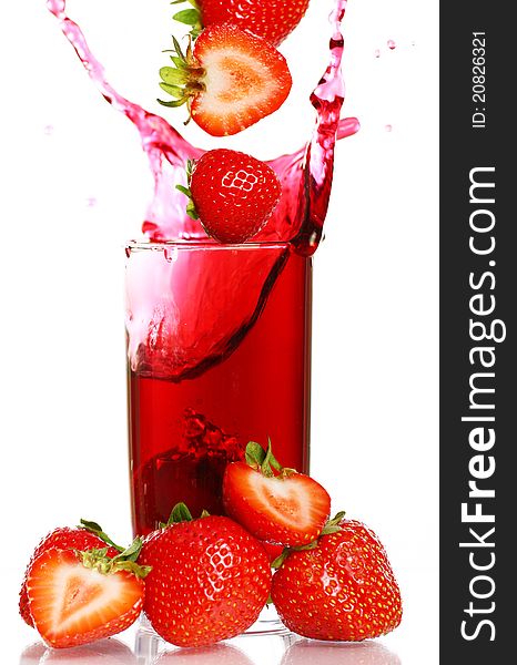 Strawberry falling into the glass with drink and makes big splashes