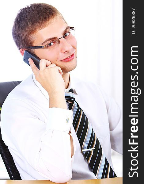 Young smiling businessman using cell phone