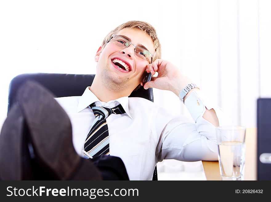 Young smiling businessman using cell phone