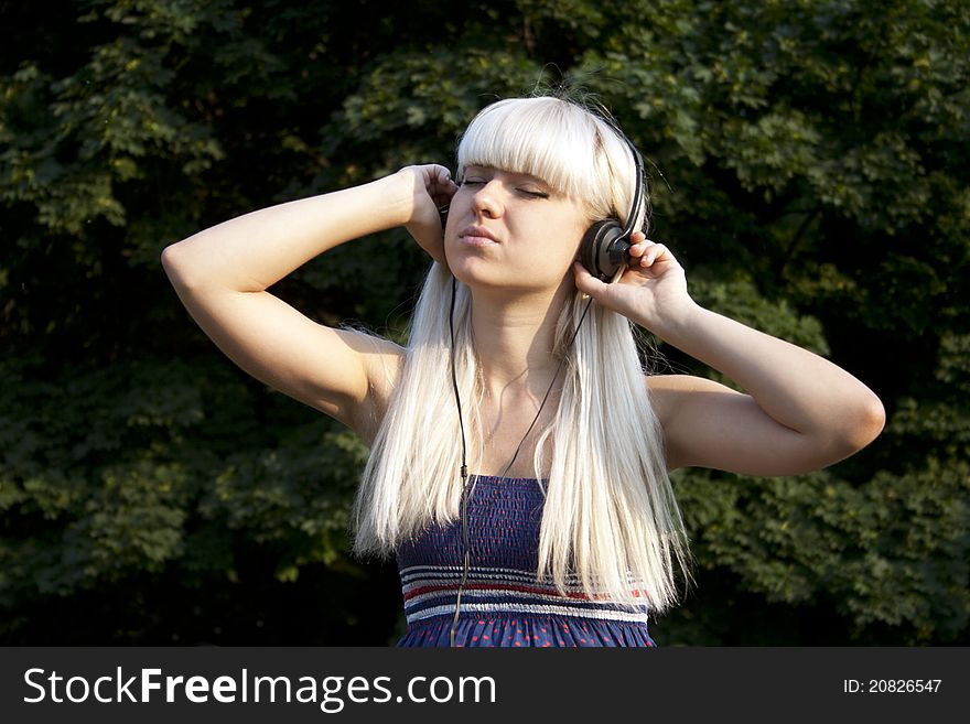 Adult girl listening to the music outdoors