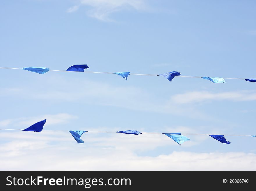 Colourful flags blowing in the wind under a bright blue sky