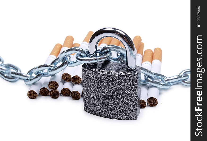 Color photo of pile of cigarettes and a padlock with chain. Color photo of pile of cigarettes and a padlock with chain
