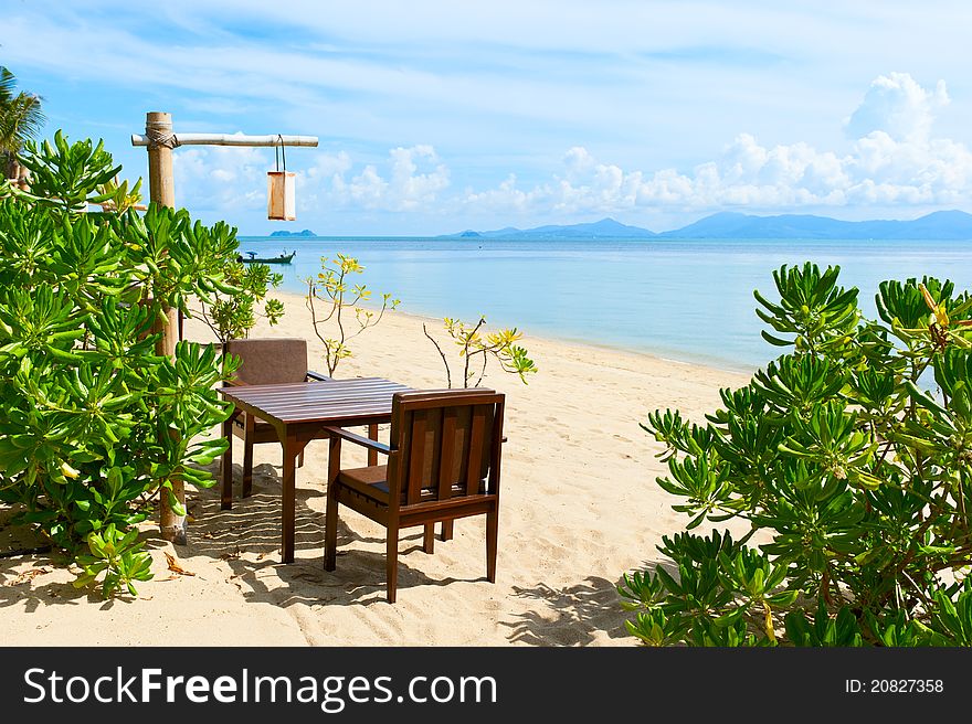 Chairs and table on beach near the sea