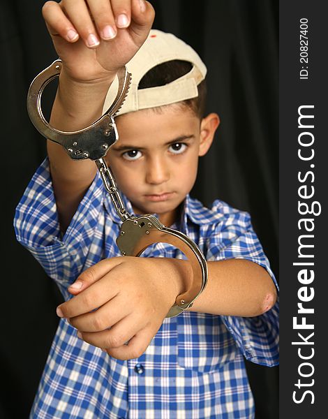 Young kid with steel-cuffs bonded. Young kid with steel-cuffs bonded