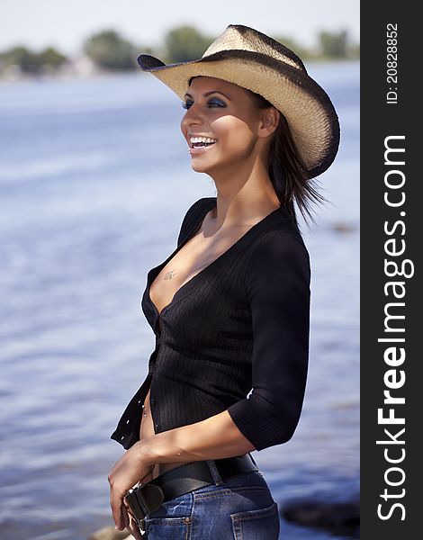 Beautiful young sexy woman smiling looking away on a river shore. Beautiful young sexy woman smiling looking away on a river shore