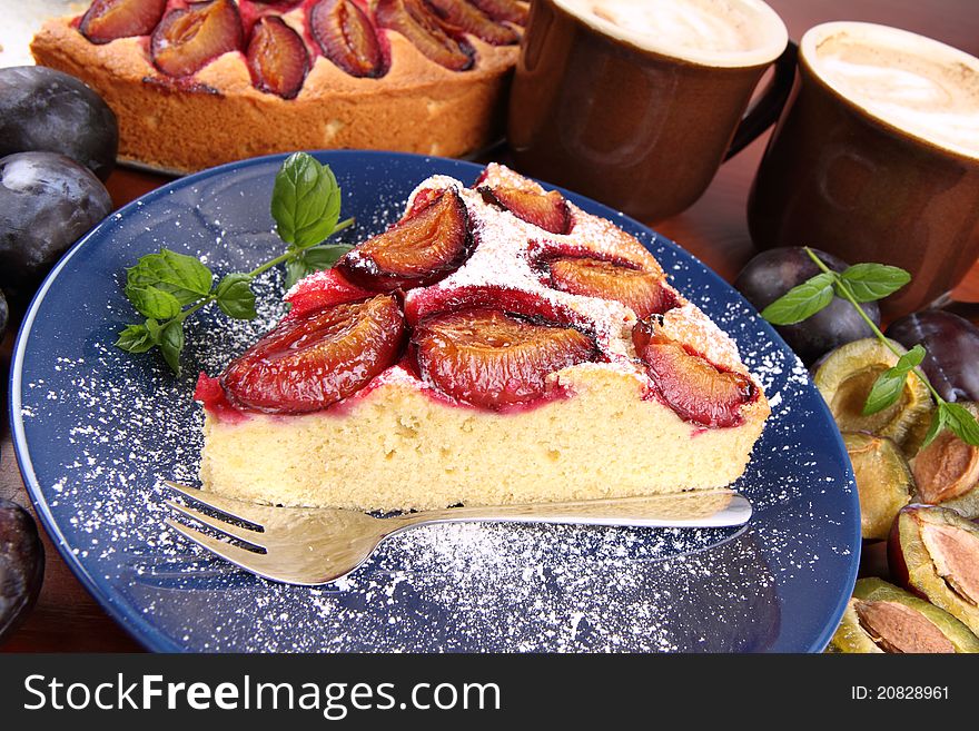 Plum pie, coffee and plums on a wooden background. Plum pie, coffee and plums on a wooden background