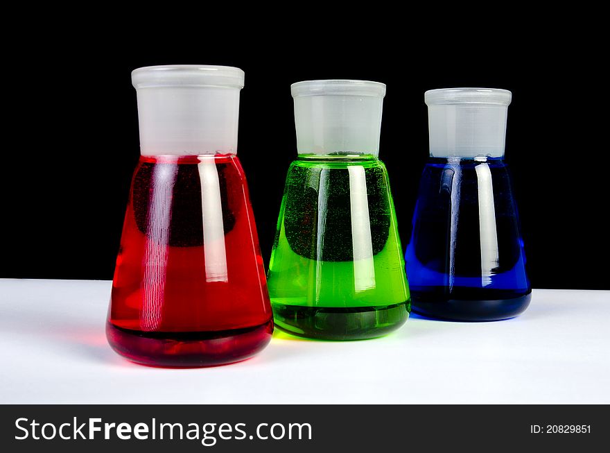 3 colors chemicals in laboratory glassware in a row. 3 colors chemicals in laboratory glassware in a row
