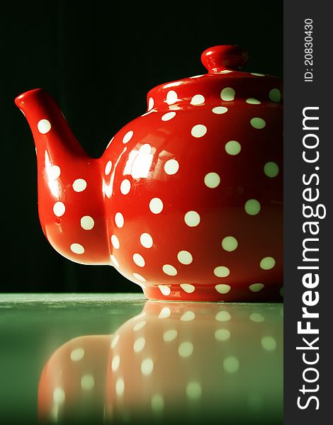 Detail of red and white dots teapot on table