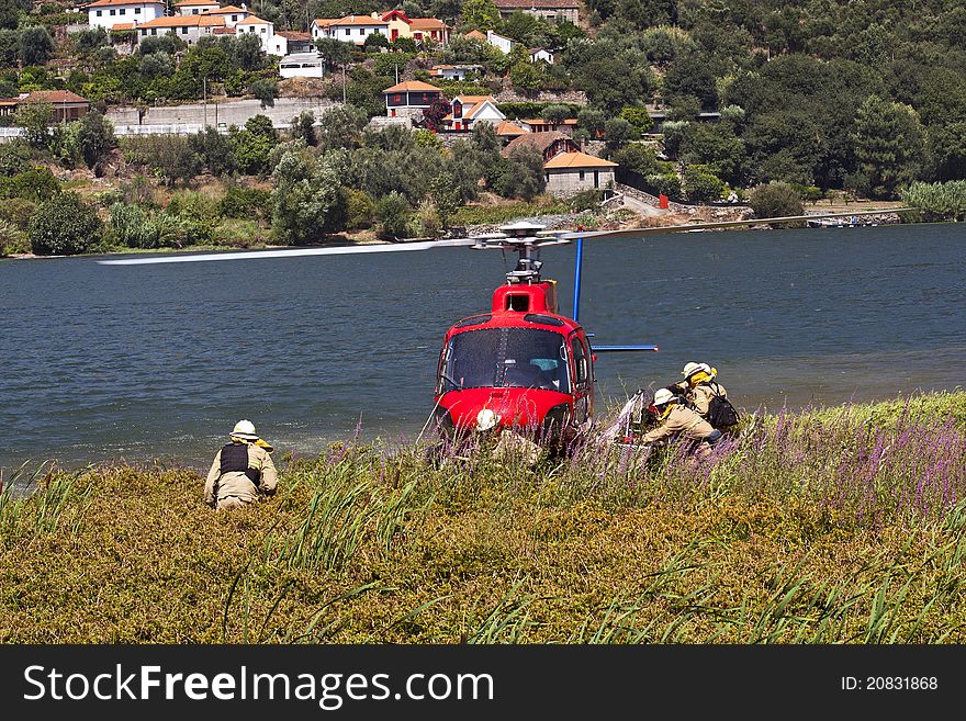 Crew of firefighters working on the helicopter stopped on the banks of the River Douro. Crew of firefighters working on the helicopter stopped on the banks of the River Douro