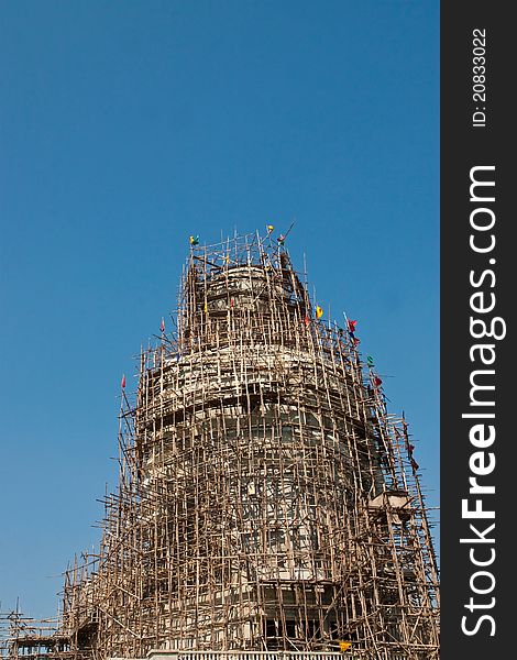 Big buddha statue under construction against blue sky