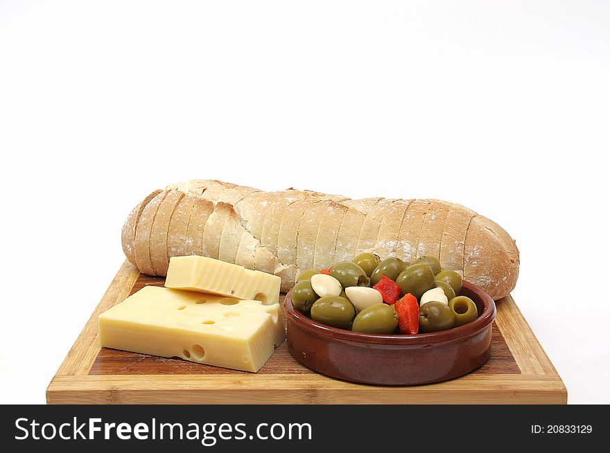 Loaf of bread sliced â€‹â€‹on wood with cheese and olives. Loaf of bread sliced â€‹â€‹on wood with cheese and olives