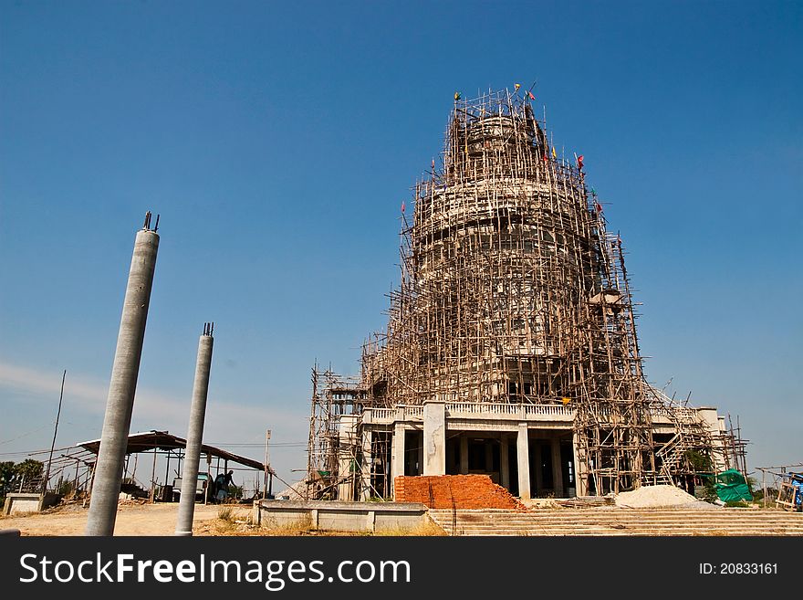 Big buddha statue under construction against blue sky