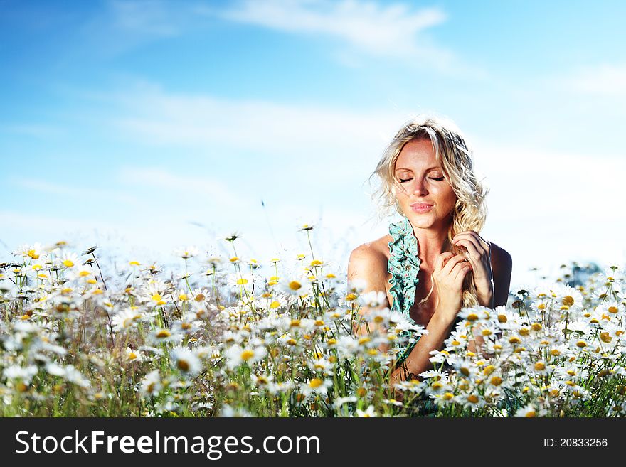 Beautiful girl on the daisy flowers field