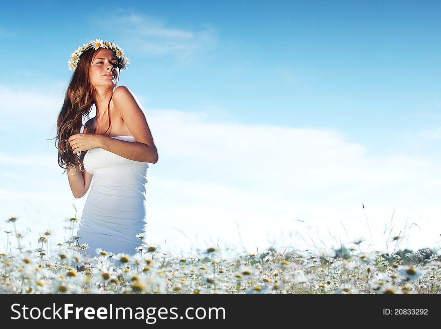 Girl in dress on the daisy flowers field