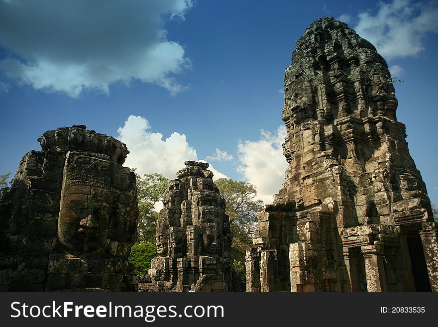 The Bayon is a Khmer temple at Angkor in Cambodia, built in the late 12th century or early 13th century as the official state temple of the Mahayana Buddhist King Jayavarman VII Following Jayavarman's death, it was modified and augmented by later Hindu and Theravada Buddhist kings in accordance with their own religious preferences. The Bayon's most distinctive feature is the multitude of serene an. The Bayon is a Khmer temple at Angkor in Cambodia, built in the late 12th century or early 13th century as the official state temple of the Mahayana Buddhist King Jayavarman VII Following Jayavarman's death, it was modified and augmented by later Hindu and Theravada Buddhist kings in accordance with their own religious preferences. The Bayon's most distinctive feature is the multitude of serene an