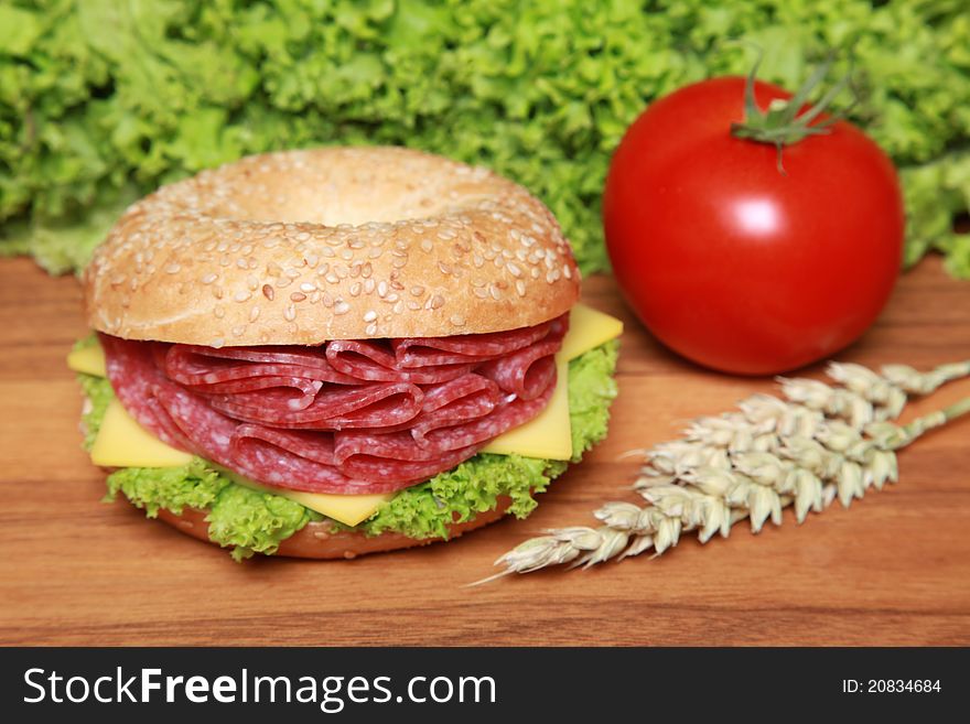 Fresh bagel with salami, cheese and lettuce