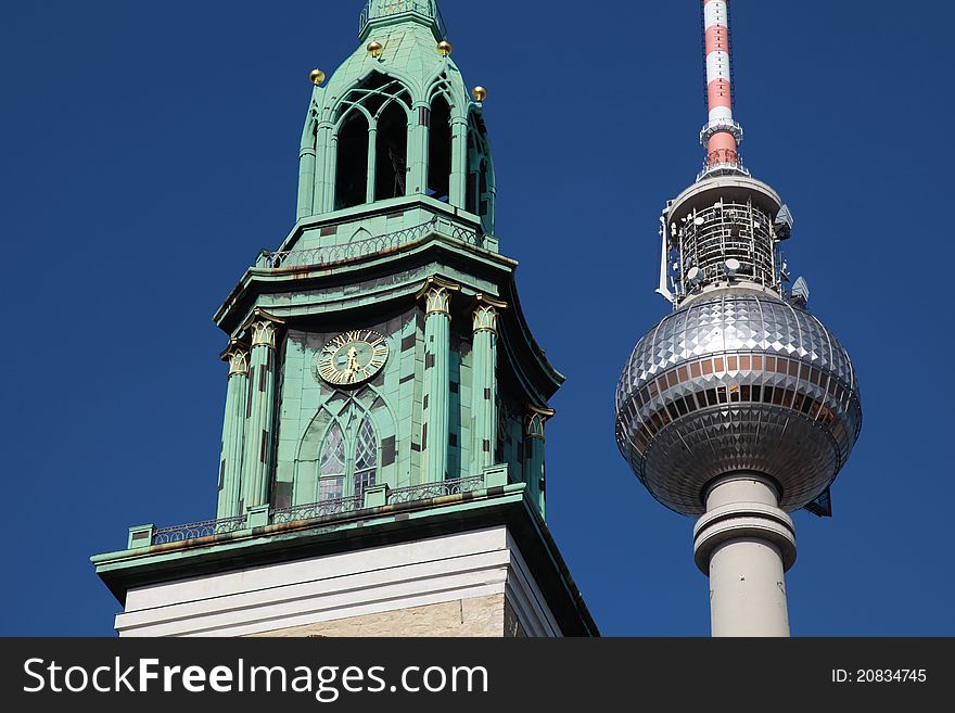 Closeup of the Berlin TV tower and the clock tower of the Nikolai church near Alexanderplatz. Closeup of the Berlin TV tower and the clock tower of the Nikolai church near Alexanderplatz.
