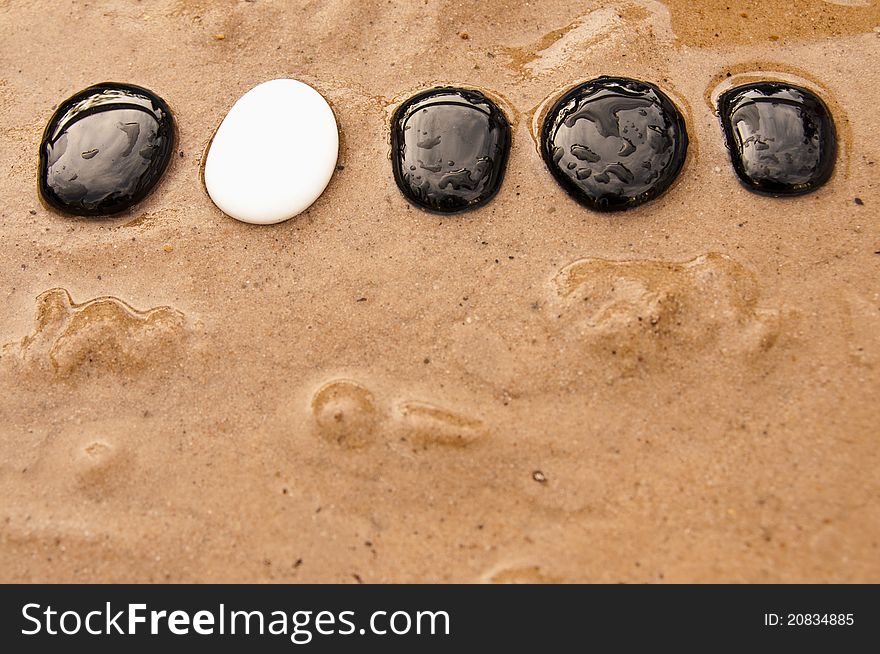 Black and white stepping stones in water and sand. Black and white stepping stones in water and sand