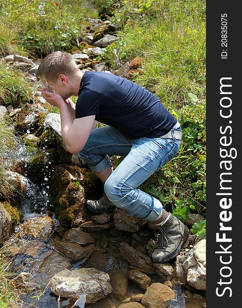 Young man taking a refreshment in the mountains