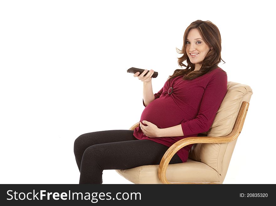 A pregnant woman sitting and watching tv.