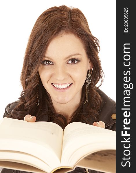 A woman holding a book close to her face with a smile. A woman holding a book close to her face with a smile.