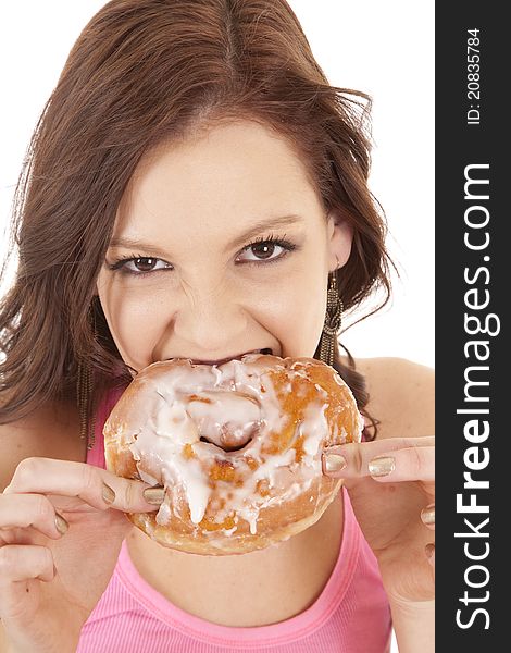A woman taking a big bite out of a doughnut. A woman taking a big bite out of a doughnut.