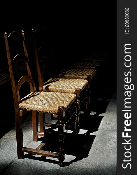 Empty wooden chairs under a spotlight. Empty wooden chairs under a spotlight