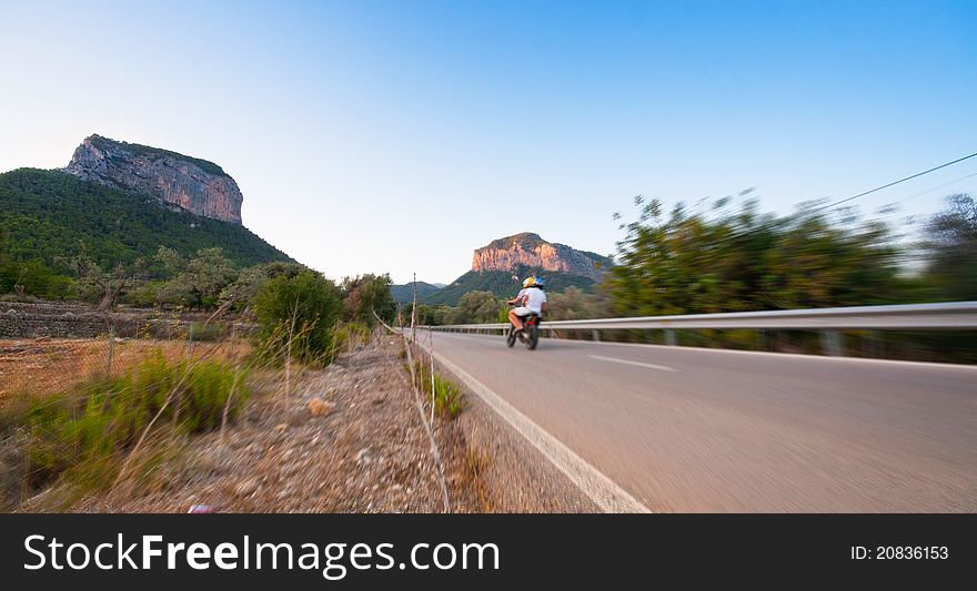 A motorcyclist cruising through the mountains. A motorcyclist cruising through the mountains