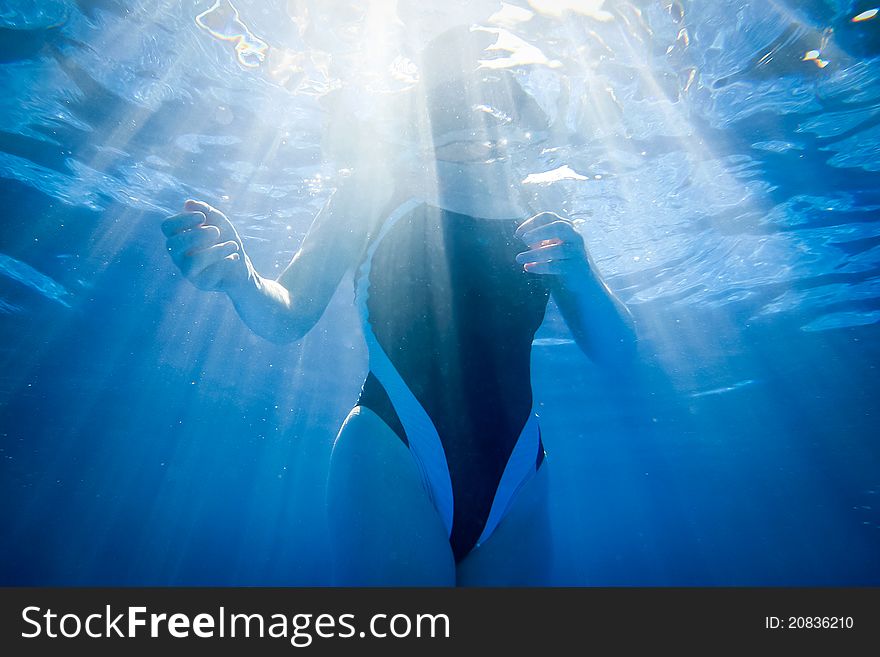 A swimmer floating in light beams. A swimmer floating in light beams