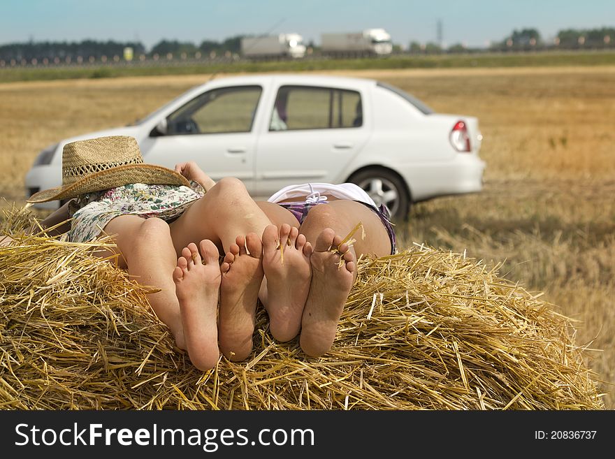 Women traveling in a car resting in a field in a haystack. Women traveling in a car resting in a field in a haystack
