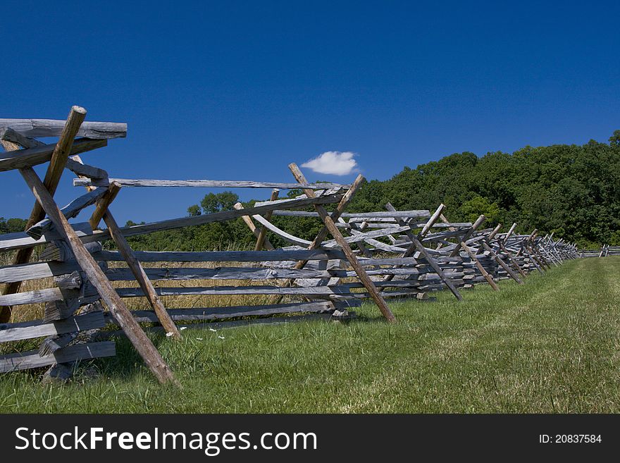 Split Rail fence stretching from lower left corner to right center under a deep blue sky. Split Rail fence stretching from lower left corner to right center under a deep blue sky