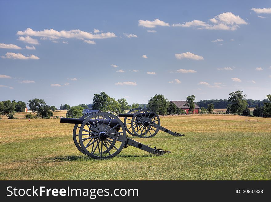 Two cannons in grass field in front of a house. Two cannons in grass field in front of a house.