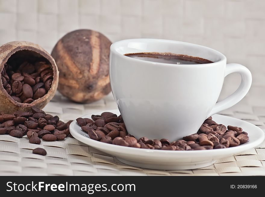 Coffee cup with roasted coffee beans, close-up