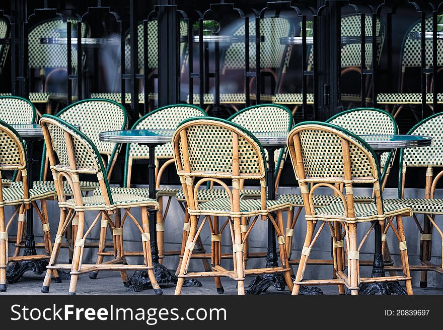 Wicker chairs in the typical cafe in Paris. Photo with tilt-shift effect. Wicker chairs in the typical cafe in Paris. Photo with tilt-shift effect