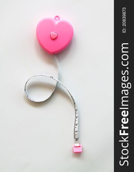 Pink heart with meter curling around on white background