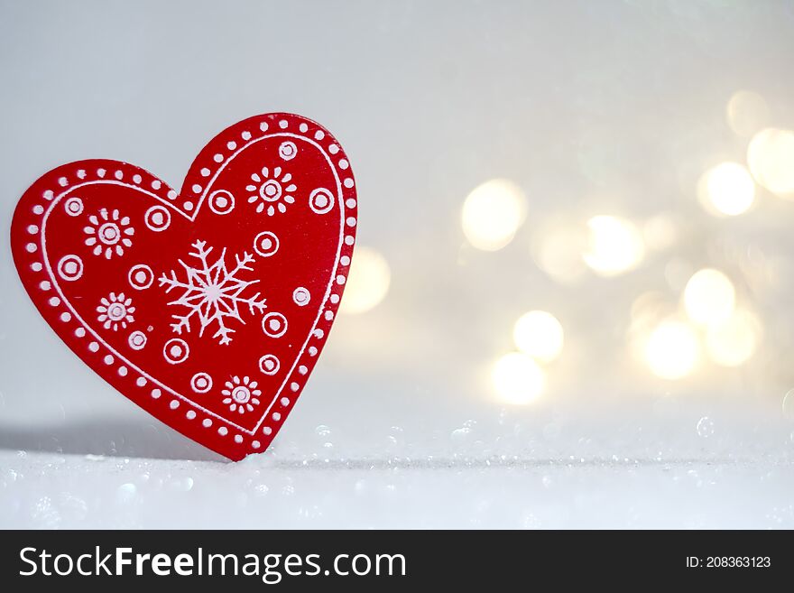 Red heart shape on snowy background with bokeh lights. Red heart shape on snowy background with bokeh lights