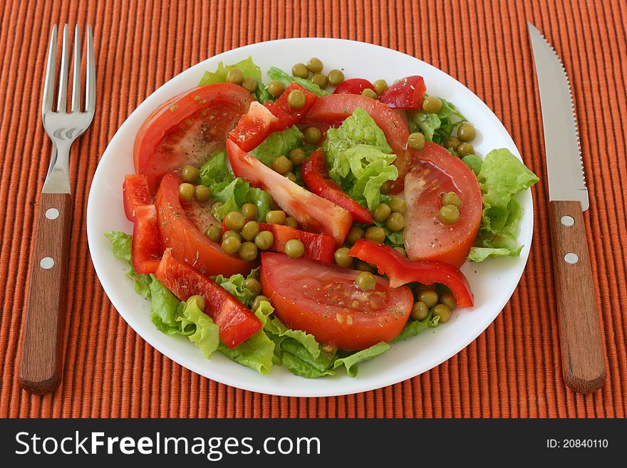 Salad with pea on an white plate