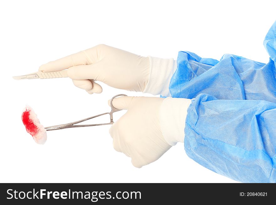 Scalpel and clamp with swab in the hand of the surgeon during a surgery. Scalpel and clamp with swab in the hand of the surgeon during a surgery