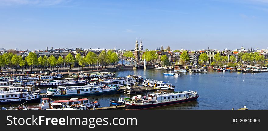 Classical Amsterdam view. Boat floats on the channel on the background of bridge. Urban scene.