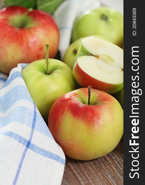 Red and green apples with leaves on the table