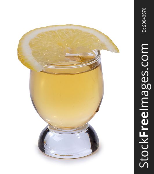 Color photo of a glass cup with tequila and lemon. Color photo of a glass cup with tequila and lemon