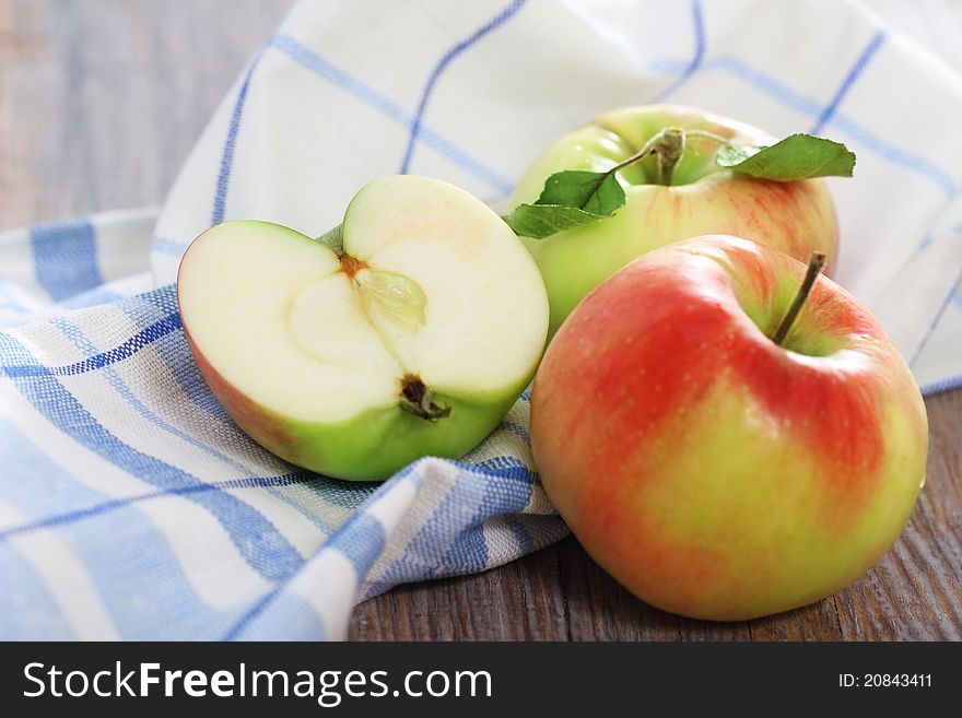Red and green apples with leaves on the table