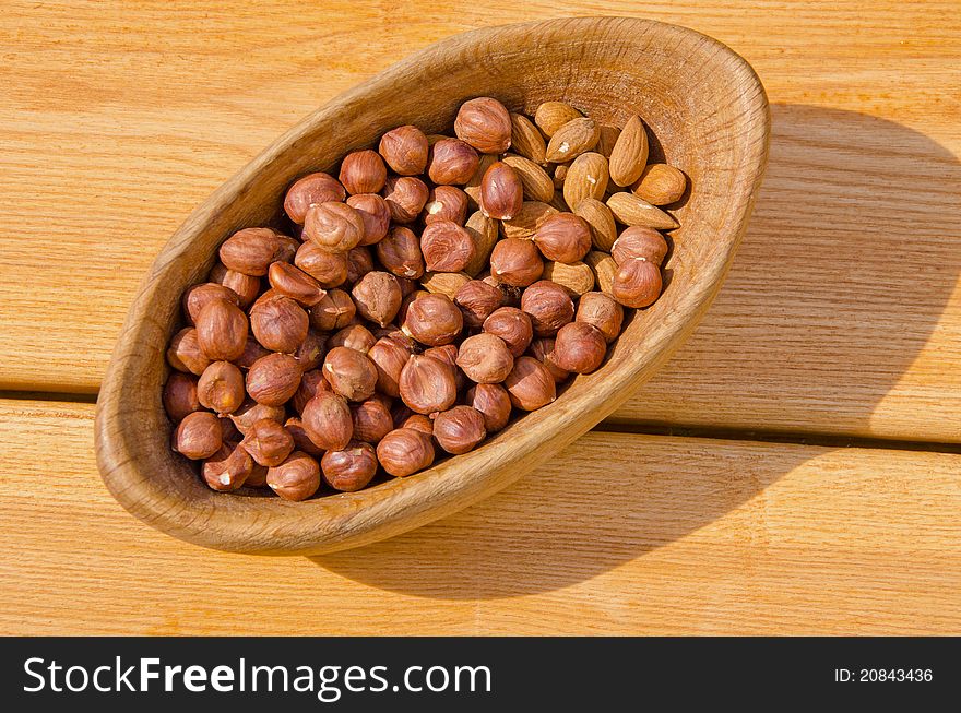 Nuts in the wooden plate on the table