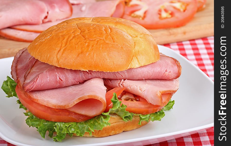 Ham sandwich with lettuce and tomato on a bun