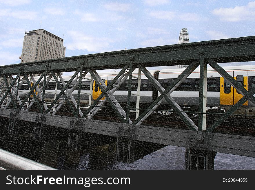 Train passing over a bridge in london city in the rain. Train passing over a bridge in london city in the rain