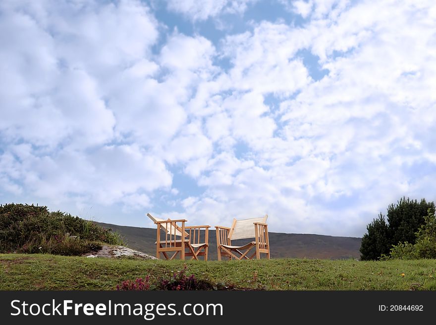 Two lone chairs on a grass hill in ireland. Two lone chairs on a grass hill in ireland